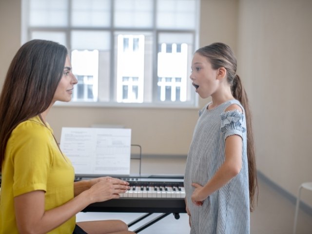 professora de música treinando melodia musical com uma menina