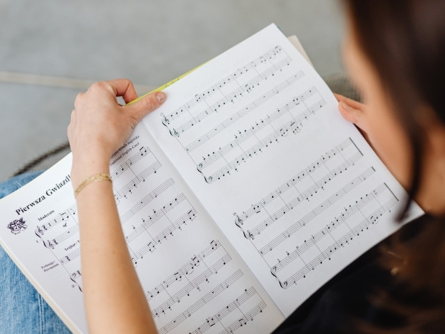 uma pessoa estudando partitura de uma música