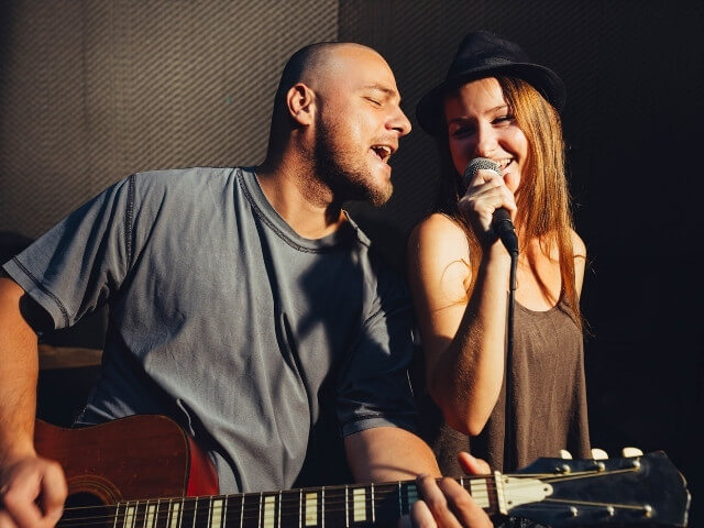 casal de cantores cantando com violão