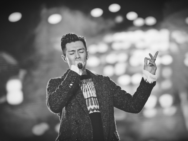 foto em preto e branco de um cantor que parece ter a voz grave se apresentando