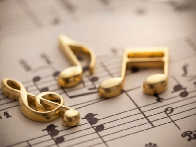 Figuras musicais sobrepostas em uma folah de papel com partitura