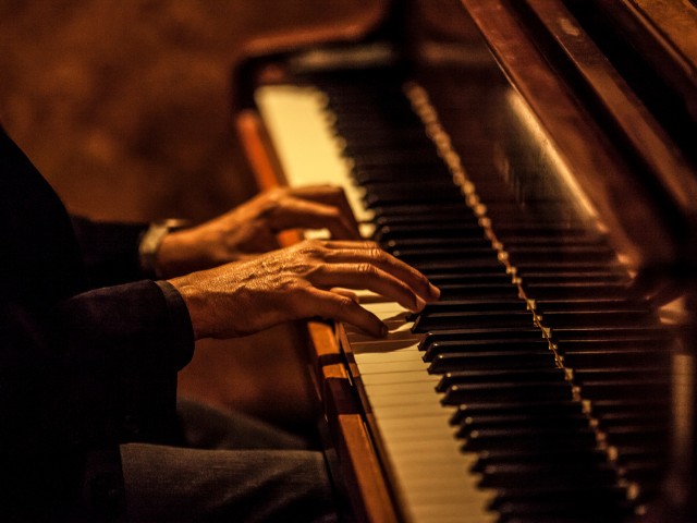 fotografia de mãos masculinas tocando piano